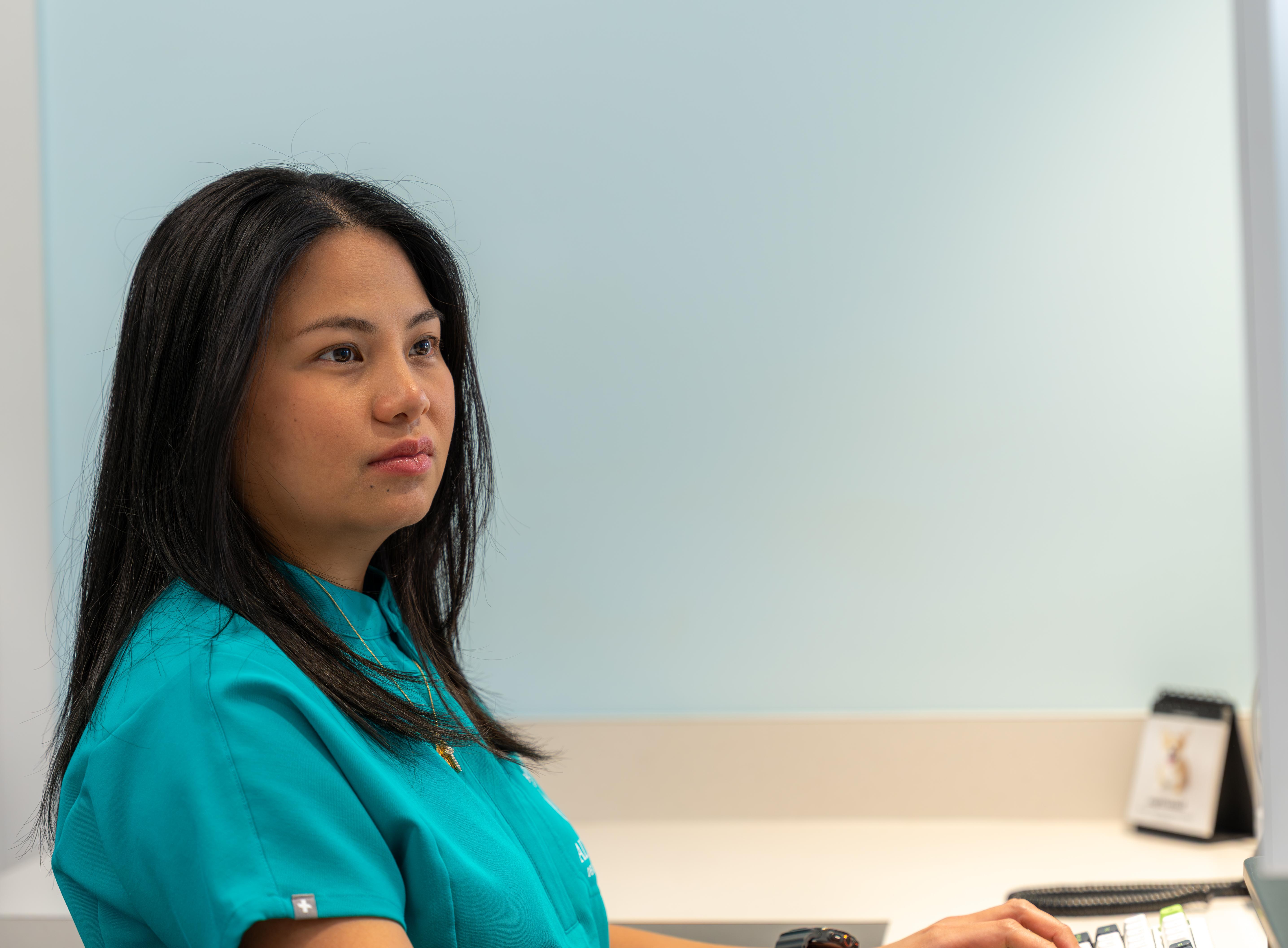 A member of the Altamar Dental Studio team working at a desk in the Naples office