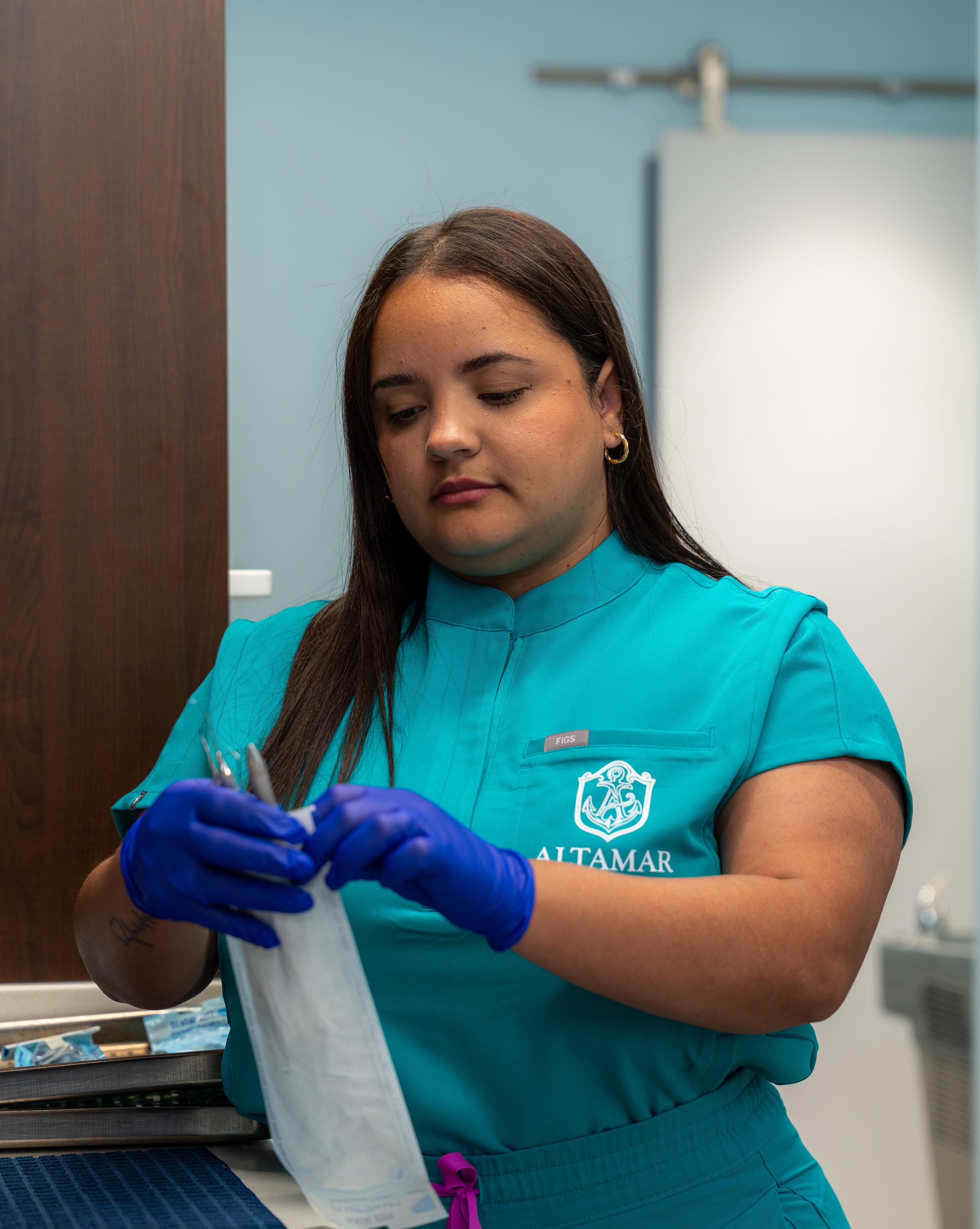Lisy, an Altamar dental assistant, preparing sterilized instruments in the office